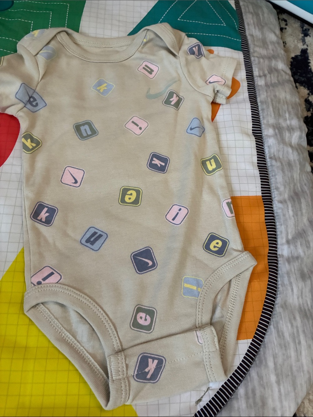 Nike Beige Baby One-Piece Bodysuit with Pastel Block Letters